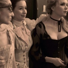 Shea Davies as a Courtesan, Emma Gutt as a Scarlet Woman, and Juliana Valente as the Madame